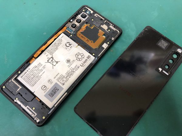 バックパネルを外したスマホが置かれています