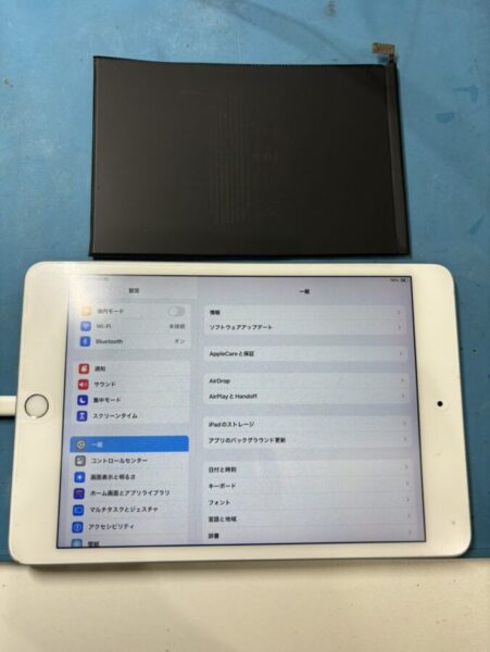 iPad mini5(第5世代)のバッテリー交換後の本体と、交換前の古いバッテリーの写真です。